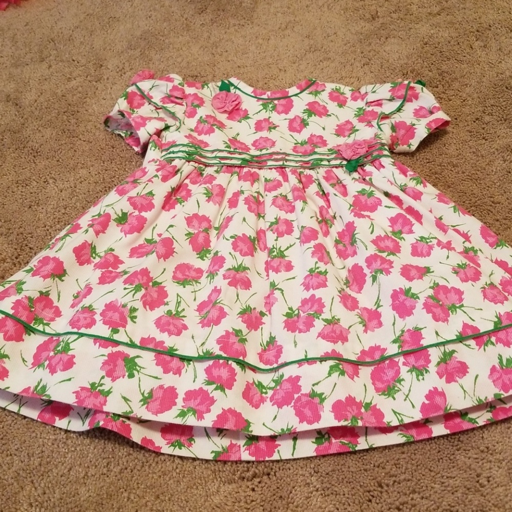 Pink and white dress with green details.